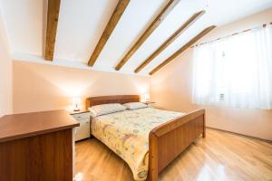 ein Schlafzimmer mit Bett, Schreibtisch und Fenster in der Unterkunft Apartments Villa Kulish in Cavtat