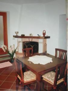 a dining room table with chairs and a fireplace at IL MORO 5 in Radicofani