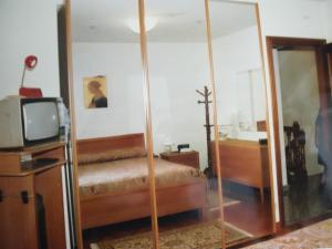 a bedroom with a mirror and a tv and a bed at IL MORO 5 in Radicofani