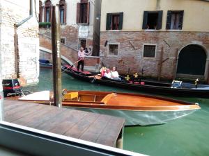 a group of people on a gondola in a canal at Casa Marco Polo in Venice