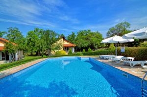a swimming pool with two umbrellas and a house at Green Life - 3 Villas with private Pool in Bryastovets