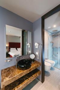 a bathroom with a sink and a mirror and a bed at Hotel Egnatia in Tirana