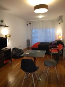 a living room with a bed and a table and chairs at Studio Río in Rosario