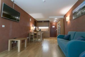 a living room with a blue couch and a table at Kubija Hotel and NatureSpa in Võru