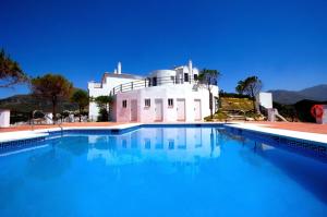 a large swimming pool in front of a house at Casares Village Bed & Breakfast in Casares