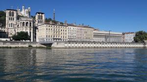 a large building next to a body of water at Hôtel de la Croix-Rousse in Lyon