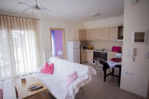 a living room with a white couch and a kitchen at Apartments Eleni 4 Seasons in Hanioti