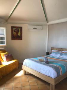 a bedroom with two beds and a couch at Morne Charlotte in Le Carbet
