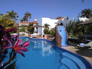 a swimming pool in front of a resort at Birdcage Gay Men Resort and Lifestyle Hotel in Playa del Ingles