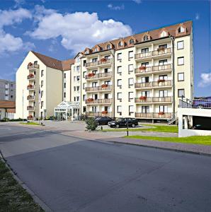 a large white apartment building on a street at Morada Hotel Gothaer Hof in Gotha