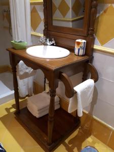 y baño con lavabo de madera y espejo. en Posada la Vieja Escuela en San Roque de Ríomiera