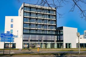 un edificio blanco alto con un letrero de la calle delante de él en Corbie Lommel Ring, en Lommel