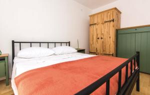 a bedroom with a bed with an orange blanket on it at Apartments Jankovic in Biograd na Moru