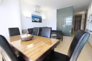 a dining room with a wooden table and black chairs at Luxury Apartment Cristianos Beachfront in Los Cristianos