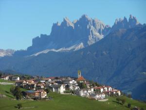 a village on a hill with mountains in the background at Gosthof Latzfons in Lazfons