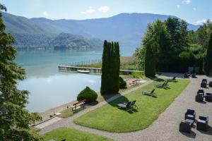 un parc avec vue sur une étendue d'eau dans l'établissement Novalaise Plage, à Novalaise