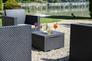 a table with two chairs and a drink on it at Novalaise Plage in Novalaise