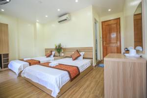 a bedroom with two beds and a kitchen with at Cat Ba Green Hotel in Cat Ba +47 photos