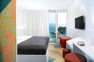a hotel room with a bed and a view of the ocean at Aminess Lišanj Family Hotel in Novi Vinodolski
