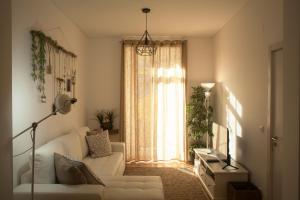 sala de estar con sofá blanco y ventana en The Marvila - Modern 3 Bedroom Apartment in trendy New Lisbon en Lisboa