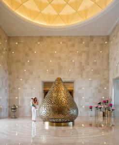 a woman standing next to a sculpture in a lobby at Four Seasons Hotel Tunis in Gammarth