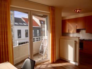 a kitchen with a large glass door to a balcony at Holiday Cottages Blankenberge in Blankenberge