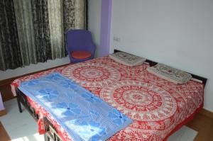 a bedroom with a bed and a blue chair at Udai Haveli Guest House in Udaipur