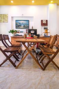 una mesa de madera y sillas en la sala de estar. en Golden Bee Homestay, en Hoi An