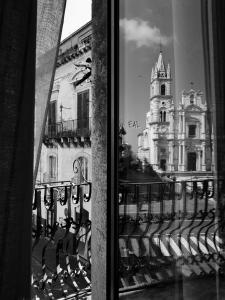 ein Fenster mit Blick auf ein Gebäude mit einem Turm in der Unterkunft Appartamenti Piazza Duomo Acireale in Acireale
