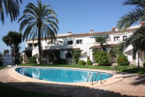a large house with a swimming pool in front of it at Apartamento Oasis Park in Denia