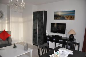 a living room with a dining table and a television at Schelvis Apartments in Zandvoort