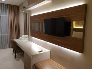 a hotel room with a television on a wall at Novena Hotel Bandung in Bandung