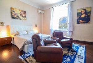 een slaapkamer met een bed, een bank en een stoel bij Appartamenti Il Sogno in Bellagio