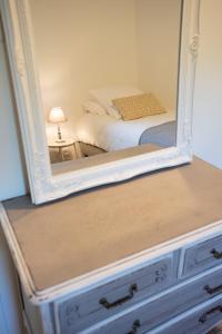 a mirror on top of a dresser with a bed at Le Champ des Oliviers in Oppède