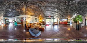 a large room with a ceiling with a couch and chairs at New Hope Inn & Suites in New Hope