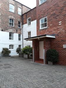 a brick building with a white door and some plants at Riverside Apartment York in York