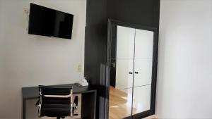Dieses schwarz-weiße Zimmer verfügt über einen Spiegel und einen Stuhl. in der Unterkunft Hotel 't Putje in Brügge