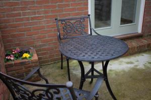 a black table and chair in front of a brick wall at Squeak Cottage in Harrogate