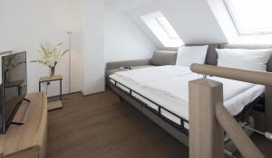 ノルダーナイにあるMeerBlickD21 Residenzenのベッドルーム1室(白いシーツ付きのベッド1台、窓付)