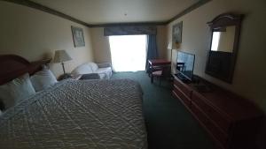 a hotel room with a bed and a television at Palace Inn & Suites in Lincoln City