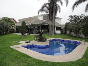 a house with a swimming pool in the yard at Cespedes House Rooms in Lima