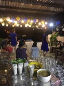 ダナンにあるHomestay Xì Trumの食卓に座る人々