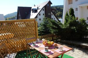 a table with a bowl of fruit on a balcony at Garden in Bjelašnica