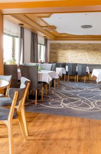 uma sala de jantar com mesas e cadeiras e um tapete em Hotel Lang em Breidenbach