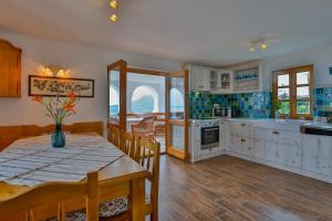 a kitchen and dining room with a table and chairs at Csendes Dűlő Szőlőbirtok Guesthouse Badacsonyörs in Badacsonytomaj