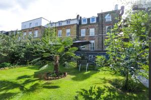 einen Garten mit einer Palme vor einem Gebäude in der Unterkunft Beckenham Park Hotel in Beckenham