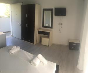 a bedroom with a bed and a mirror and a dresser at Sea View Hotel Dhermi in Dhërmi