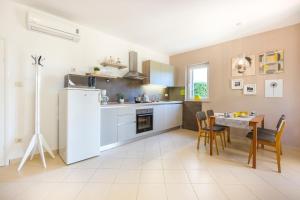 a kitchen and dining room with a table and a refrigerator at Apartment Andrea in Sveta Marina
