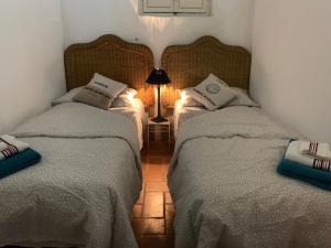 two twin beds in a room with a lamp at Casa delle Galee in Scilla
