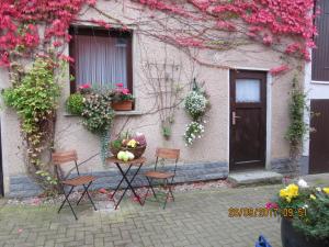 a table and chairs in front of a building with flowers at Stadtzentrum , nähe Schloss in Klütz